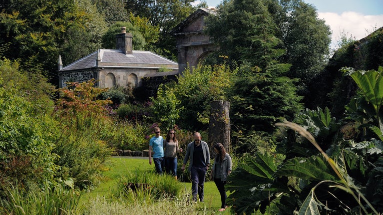 A photograph of a group walking through Bishop's Gate gardens.